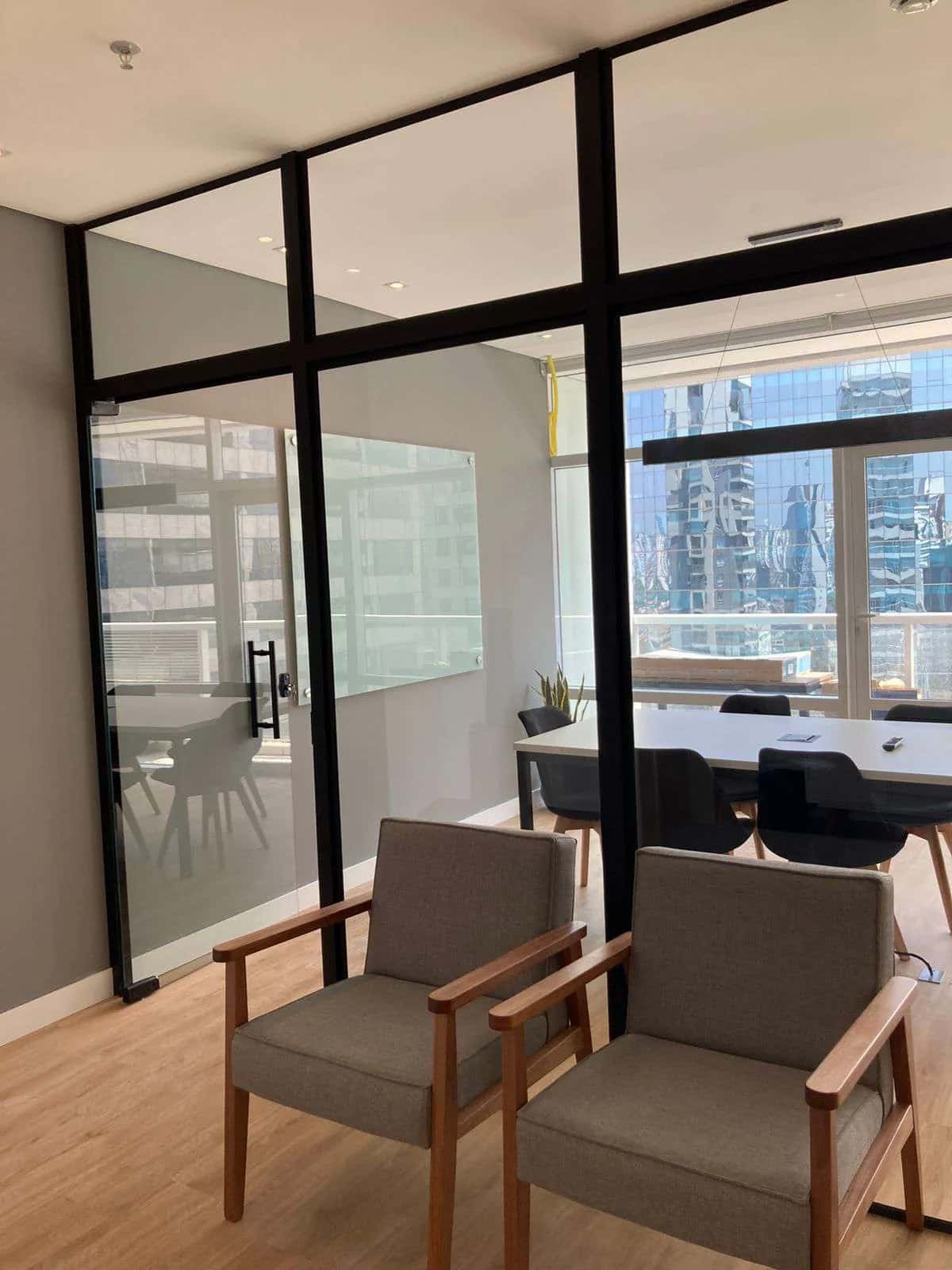 Glass-walled meeting room with a view of the city's buildings